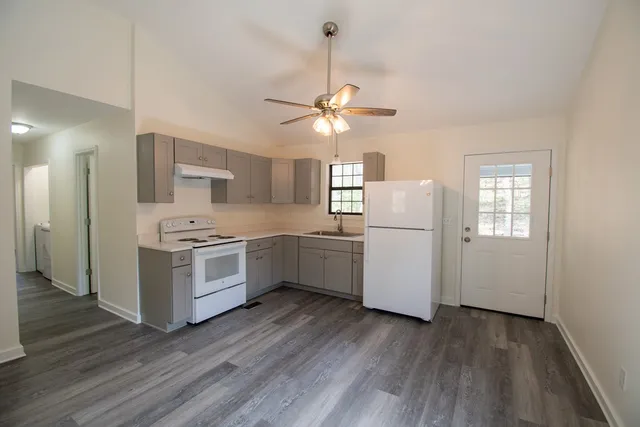 a kitchen with white cabinets and white appliances