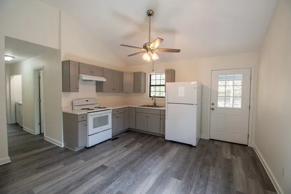 a kitchen with white cabinets and white appliances