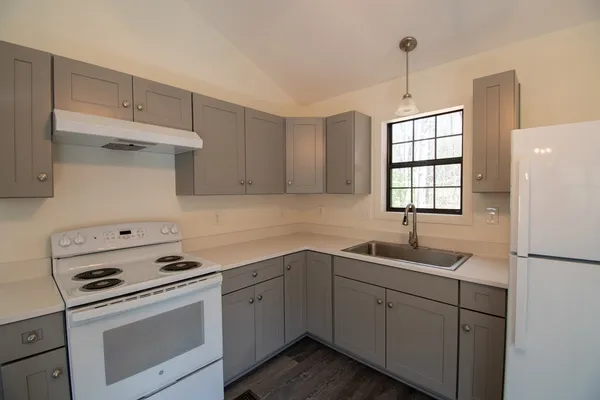 a kitchen with cabinets appliances a sink and a window