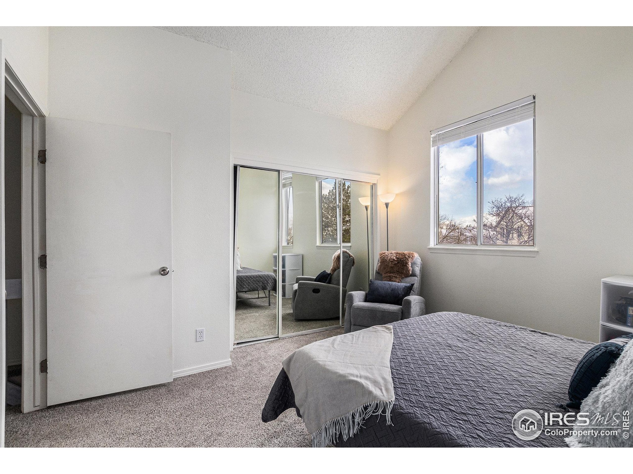 4911 Garrison Street, Unit 206G Wheat Ridge, CO 80033 - Photo 12 of 20 a bedroom with a bed and a large mirror