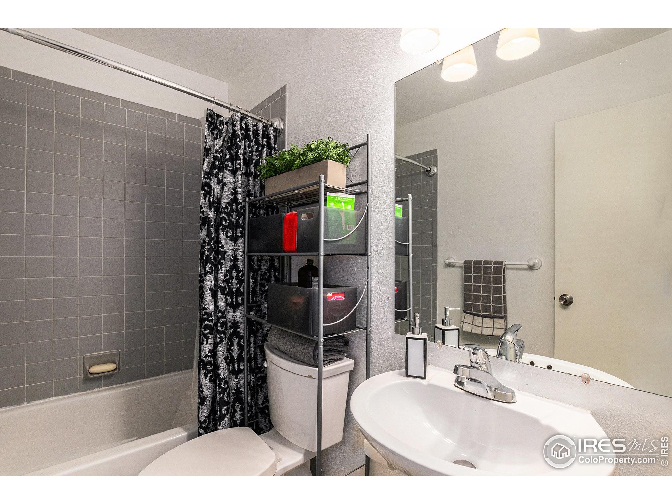 4911 Garrison Street, Unit 206G Wheat Ridge, CO 80033 - Photo 7 of 20 a bathroom with a sink a toilet and shower