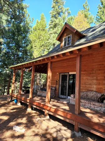 a view of a porch with a floor to ceiling window and wooden fence