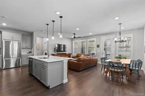 a large kitchen with kitchen island a wooden floor and outdoor dining space