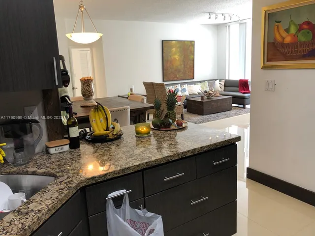 a kitchen with sink and view of living room
