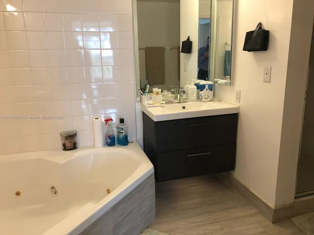a bathroom with a tub sink and mirror