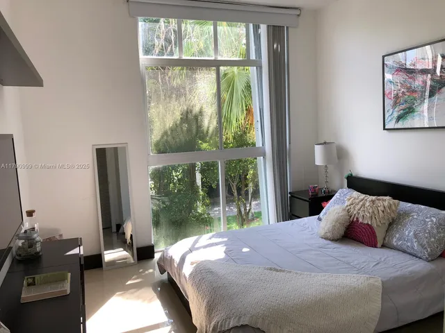 a bedroom with a bed and a large window