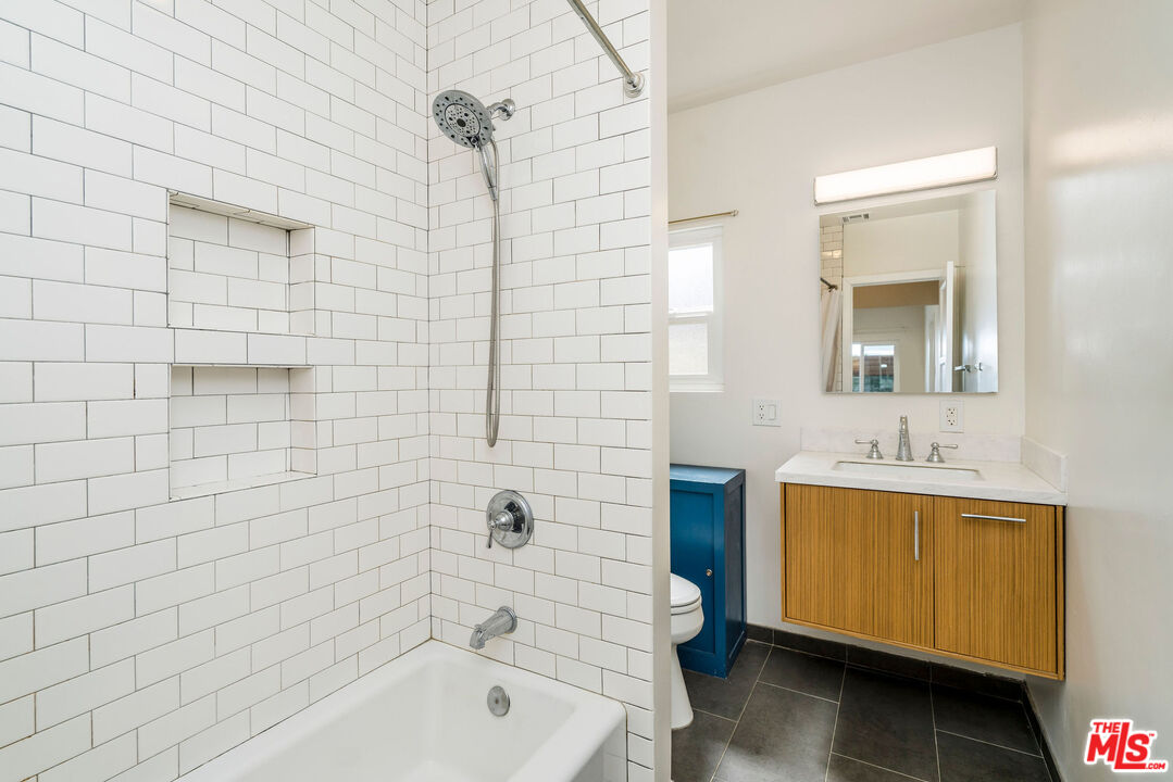1215 North Avon Street Burbank, CA 91505 - Photo 19 of 37 a bathroom with a bath tub a sink and mirror