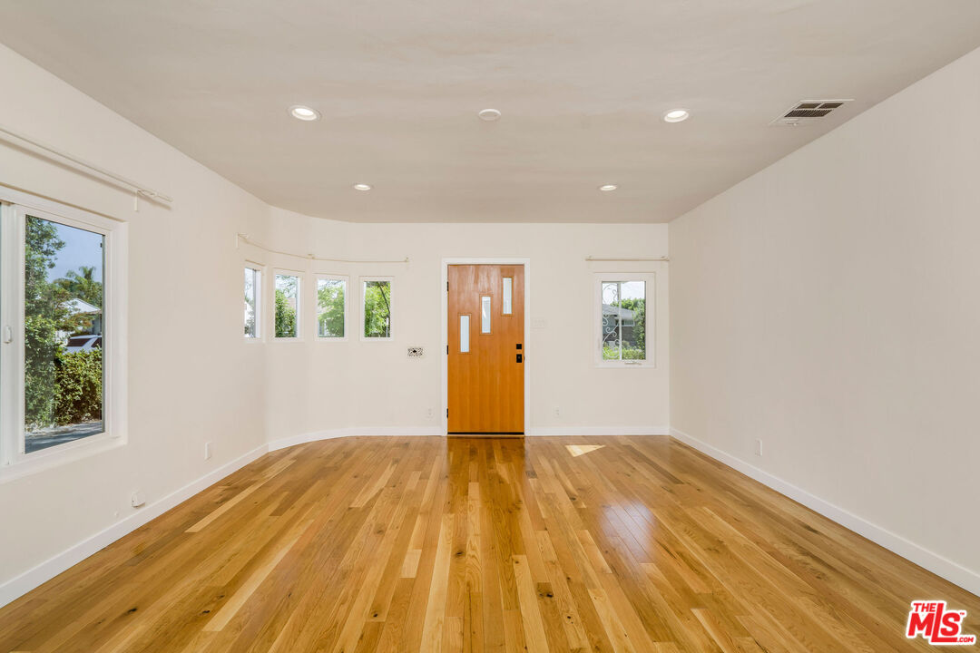 1215 North Avon Street Burbank, CA 91505 - Photo 5 of 37 a view of empty room with wooden floor and fan