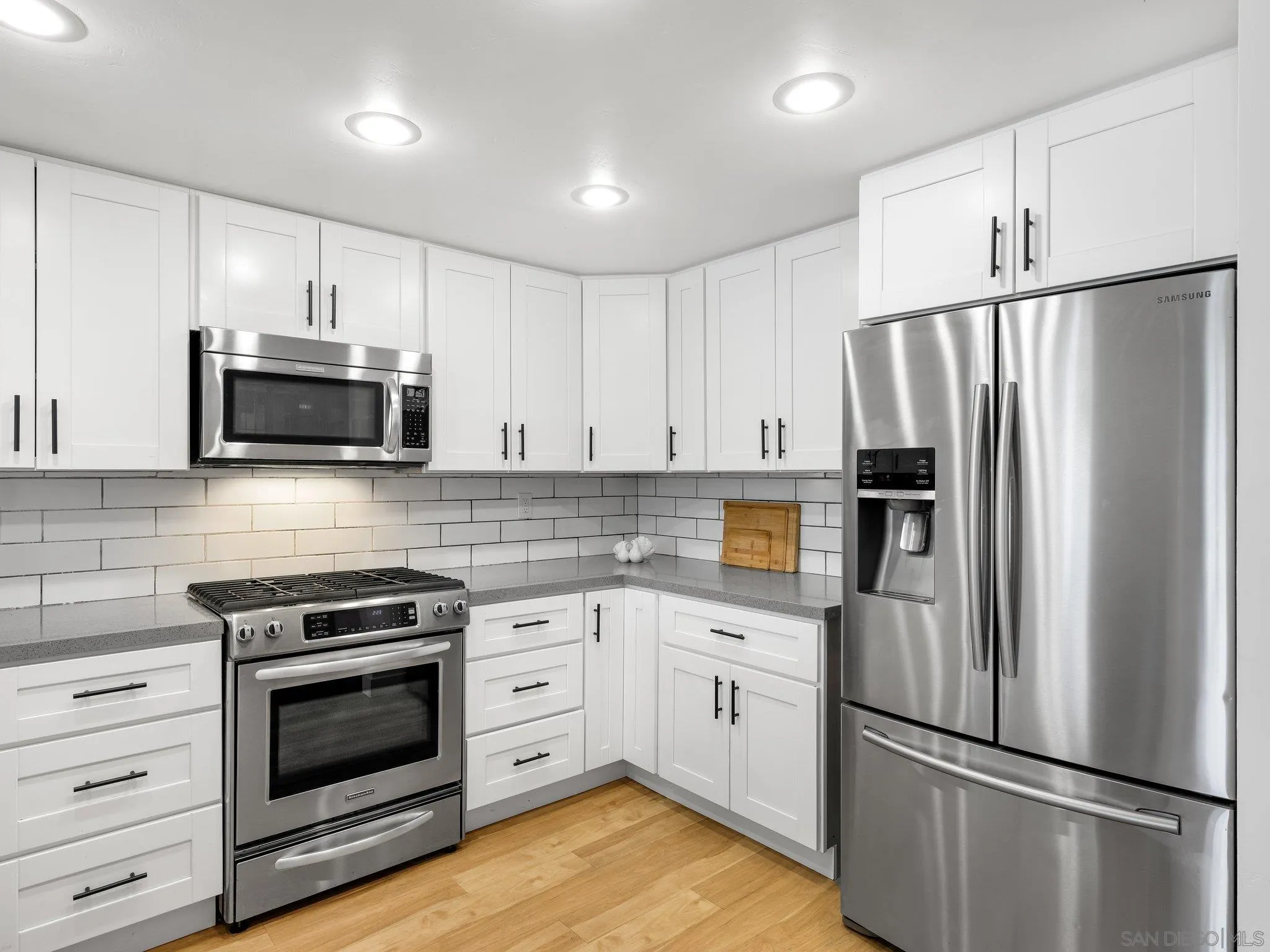 14813 Morningside Drive Poway, CA 92064 - Photo 10 of 37 a kitchen with white cabinets and stainless steel appliances