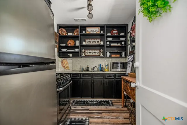 a kitchen with stainless steel appliances granite countertop a stove and cabinets