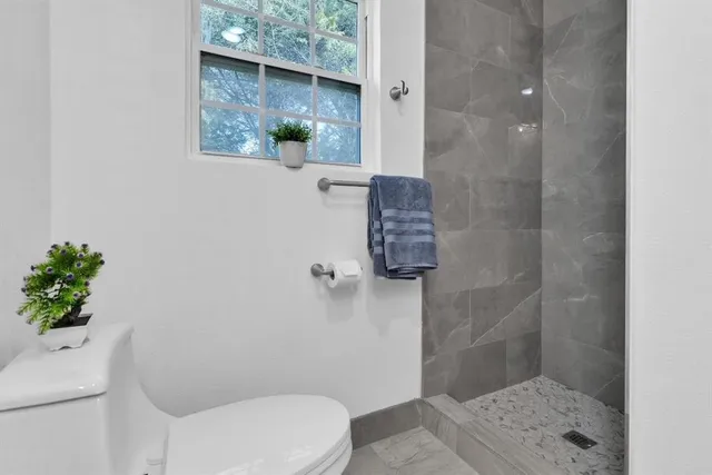 a bathroom with a toilet and a shower