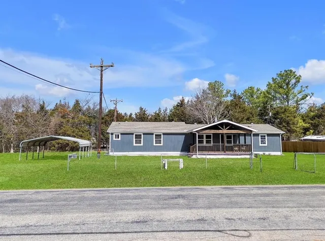 a view of a house with a yard and potted plants