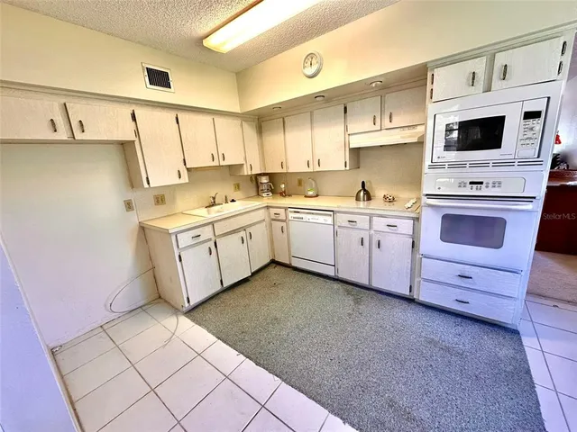 a kitchen with a sink a stove and cabinets