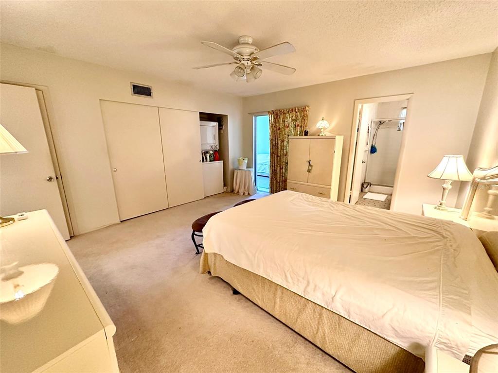 2404 Florentine Way, Unit 2 Clearwater, FL 33763 - Photo 9 of 37 a spacious bedroom with a bed and a chandelier
