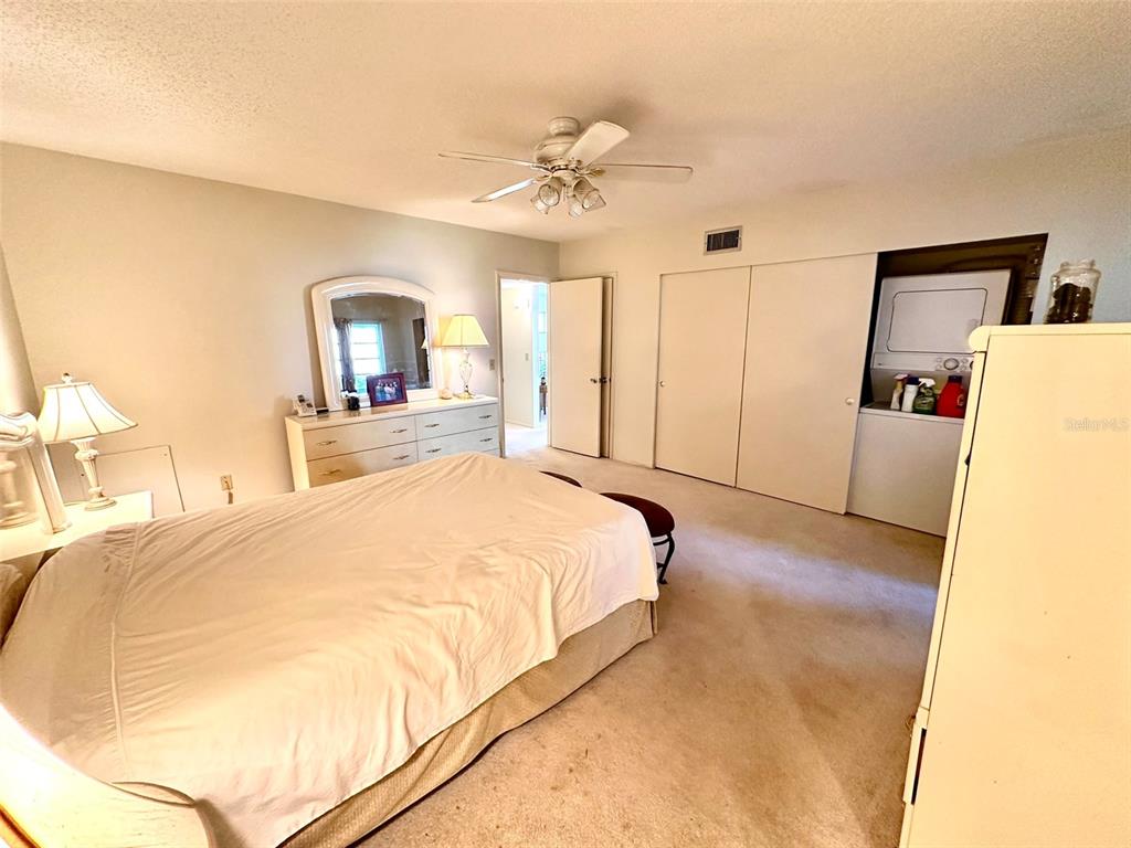 2404 Florentine Way, Unit 2 Clearwater, FL 33763 - Photo 10 of 37 a spacious bedroom with a bed and a chandelier