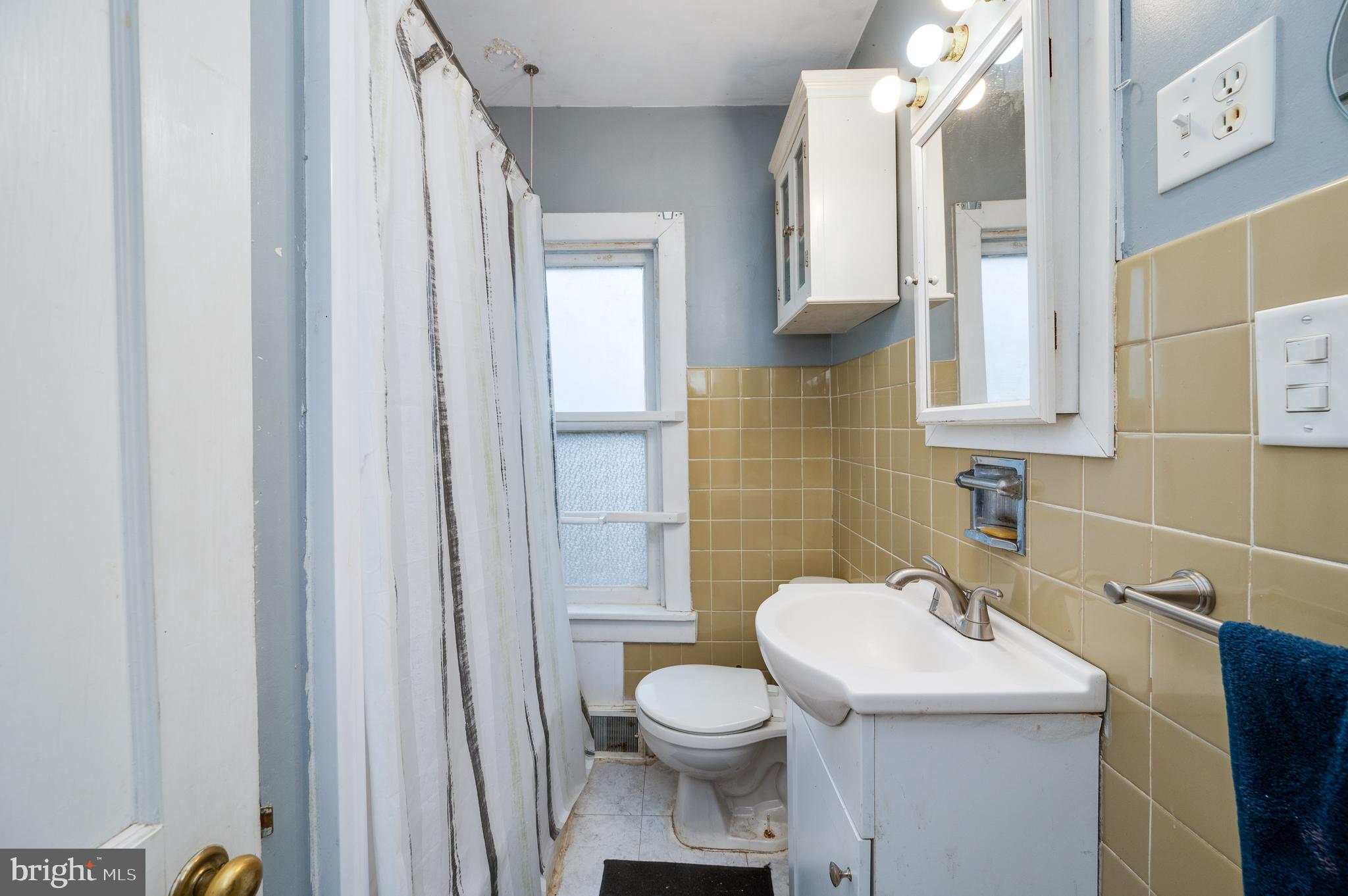 817 Philadelphia Avenue Reading, PA 19607 - Photo 14 of 20 a bathroom with a sink a toilet and shower curtain