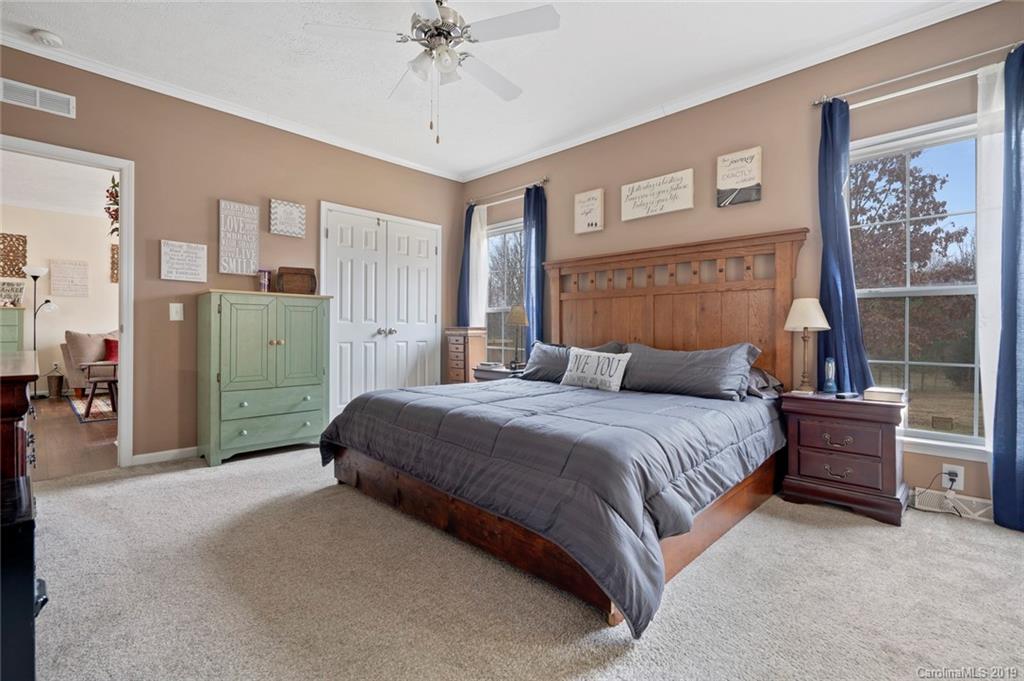 2804 Plyler Mill Road Lancaster, SC 29720 - Photo 19 of 32 a bedroom with a bed and a chandelier
