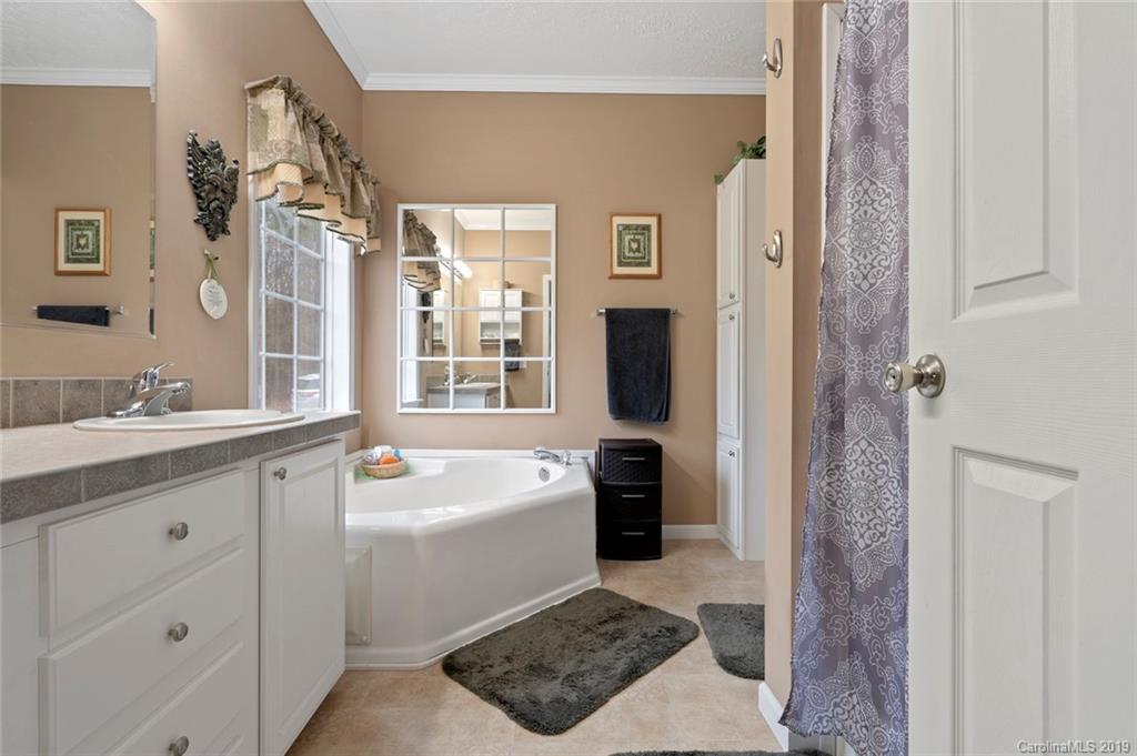 2804 Plyler Mill Road Lancaster, SC 29720 - Photo 20 of 32 a bathroom with a sink a toilet a shower a mirror and bathtub
