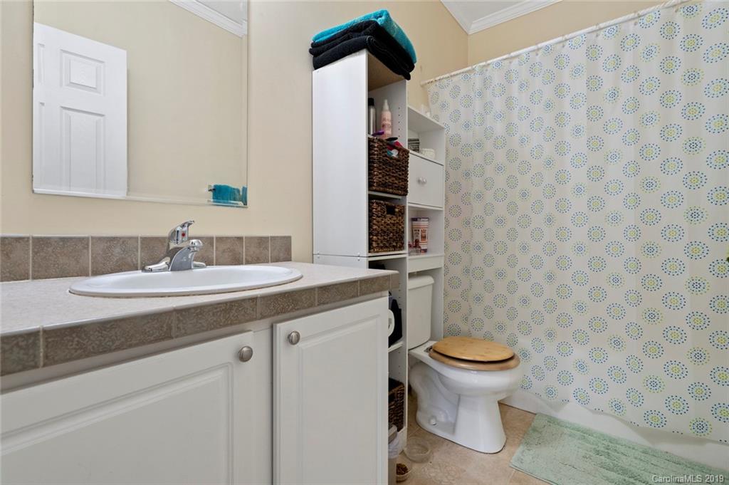 2804 Plyler Mill Road Lancaster, SC 29720 - Photo 26 of 32 a bathroom with a granite countertop toilet a sink and a mirror