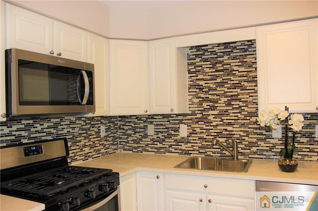 43 Alpine Road Holmdel, NJ 07733 - Photo 9 of 25 a kitchen with granite countertop a stove and a microwave