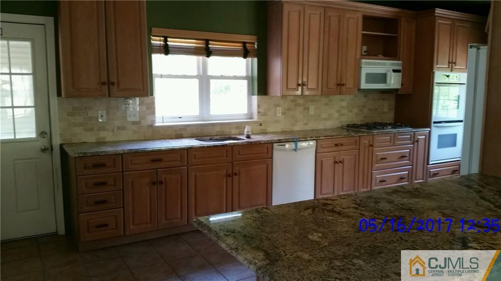 134 North Bergen Mills Road Monroe Township, NJ 08831 - Photo 4 of 11 a kitchen with kitchen island granite countertop a sink cabinets and window