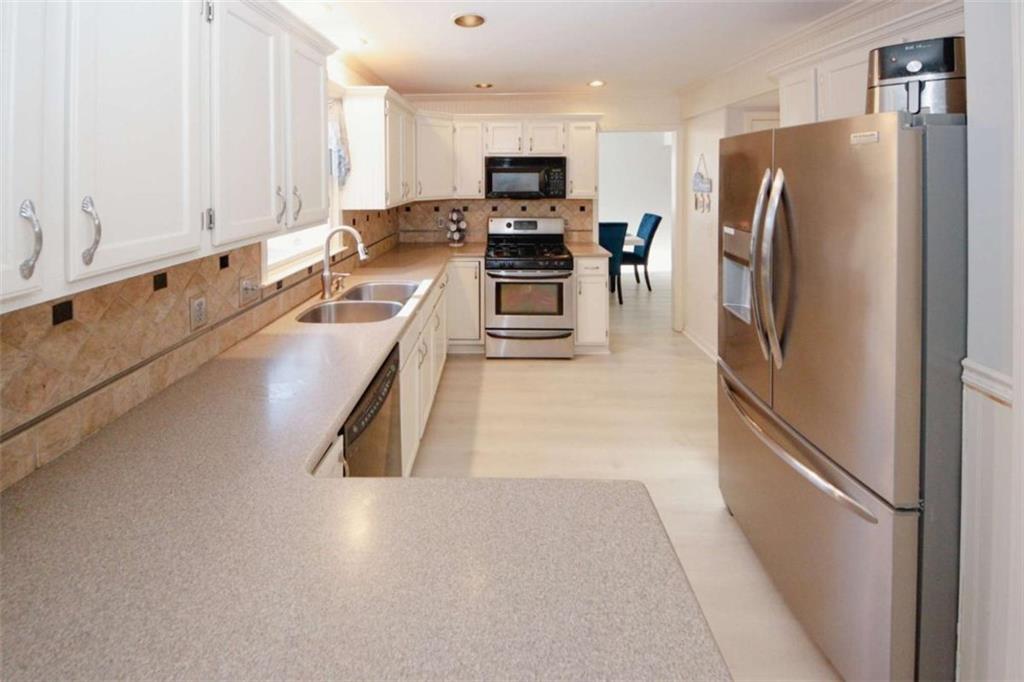 4025 Ivy Run Circle Duluth, GA 30096 - Photo 11 of 34 a kitchen with stainless steel appliances granite countertop a refrigerator a stove and a sink