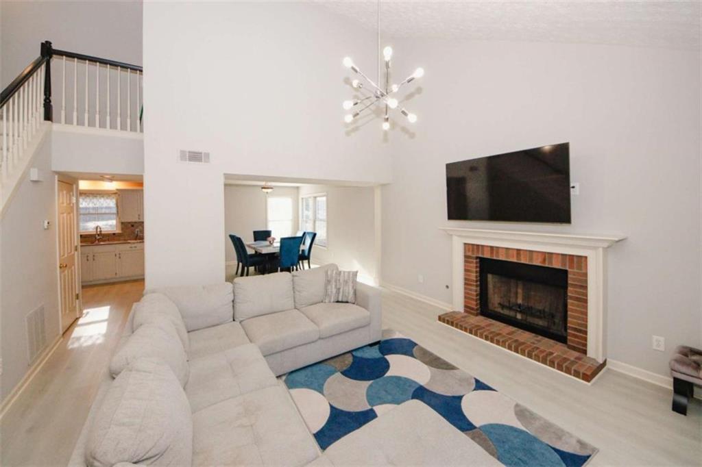 4025 Ivy Run Circle Duluth, GA 30096 - Photo 7 of 34 a living room with furniture a fireplace and a flat screen tv