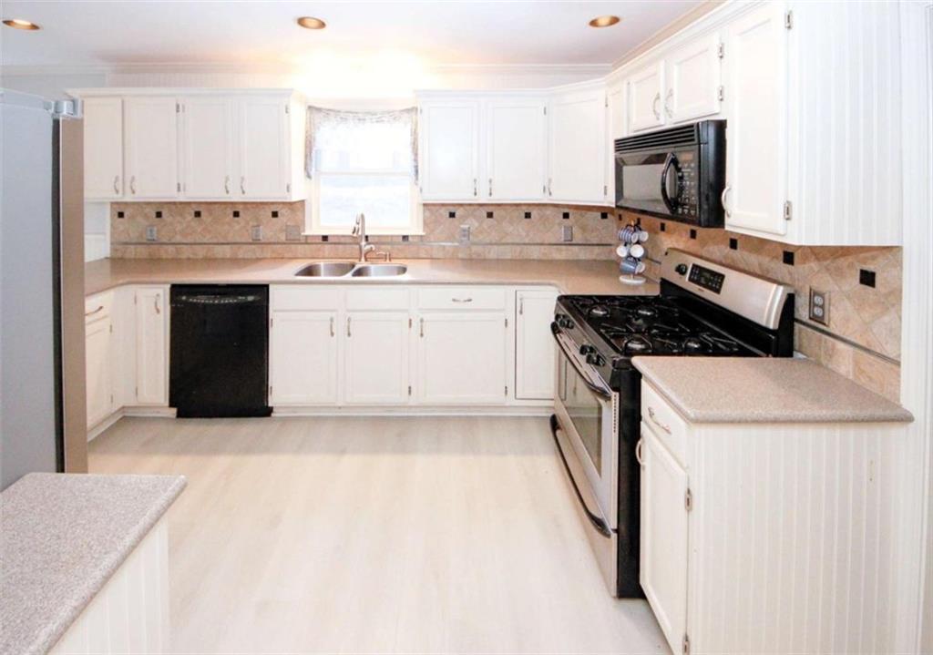4025 Ivy Run Circle Duluth, GA 30096 - Photo 10 of 34 a kitchen with stainless steel appliances white cabinets a sink and a stove
