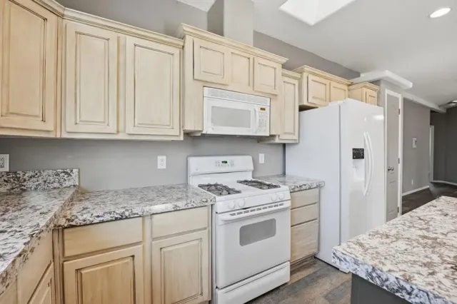 a kitchen with white cabinets and white appliances