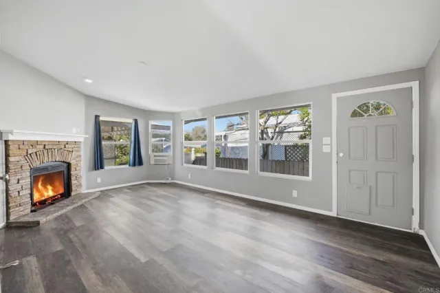 a view of an empty room with window and fire place
