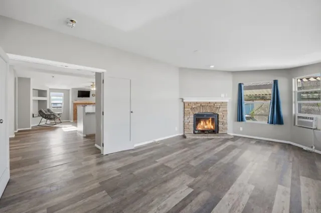 a view of a livingroom with wooden floor and a fireplace