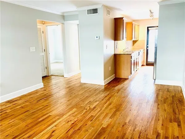 a view of empty room with wooden floor