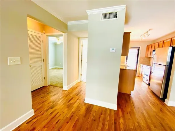 a view of a hallway with wooden floor and staircase