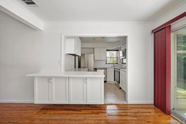 a view of a kitchen with wooden floor and a window
