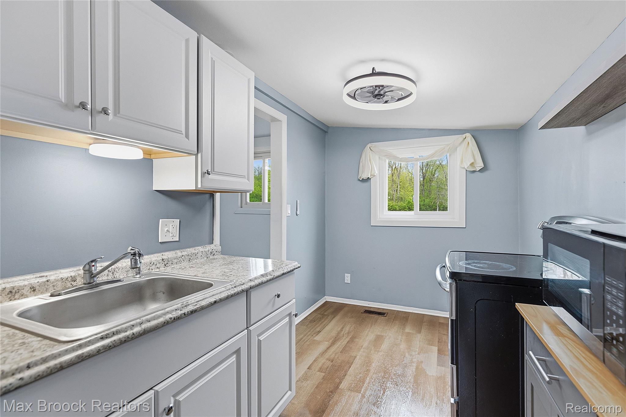 1392 Maple Grove Road Lapeer, MI 48446 - Photo 36 of 70 Laundry room featuring light wood-style flooring and a sink