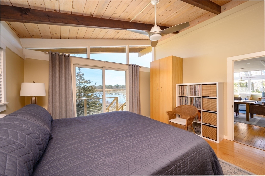 97 Bells Neck Road West Harwich, MA 02671 - Photo 13 of 41 a bedroom with a large bed and a chandelier