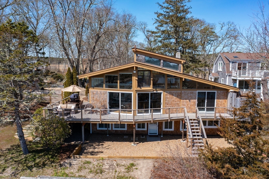 97 Bells Neck Road West Harwich, MA 02671 - Photo 2 of 41 a view of house with yard outdoor seating and covered with trees