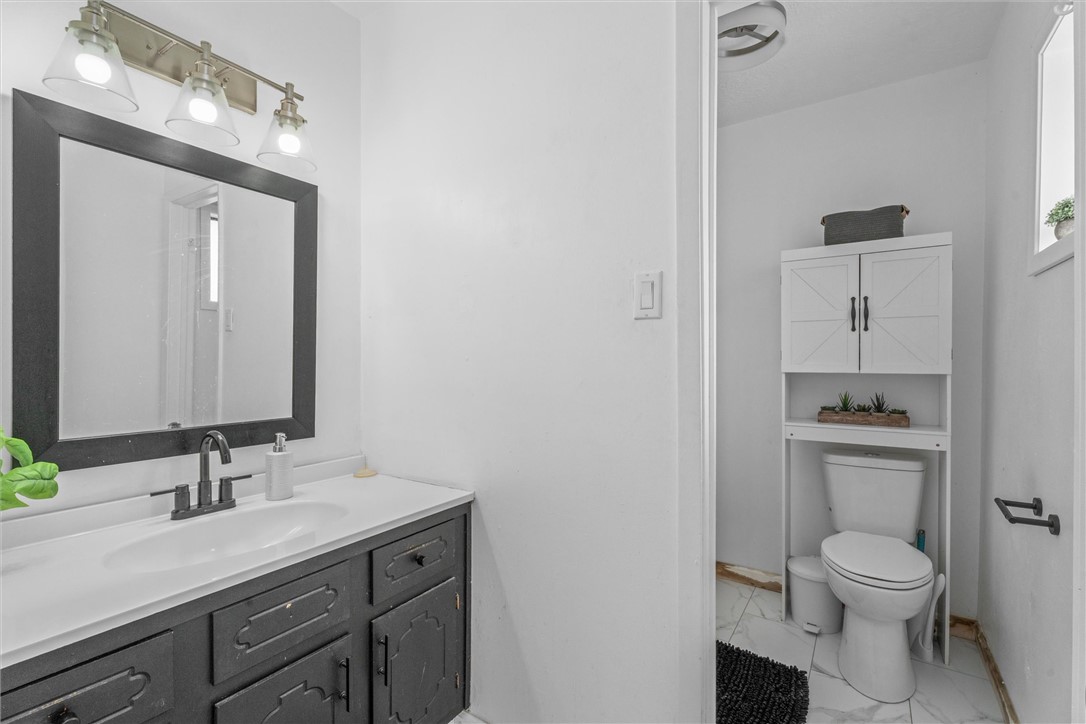 3511 Pecos Court Bryan, TX 77801 - Photo 15 of 22 a bathroom with a toilet a sink a mirror and vanity