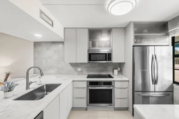 a kitchen with stainless steel appliances a refrigerator sink and microwave