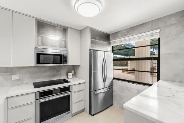 a kitchen with stainless steel appliances a refrigerator sink and microwave