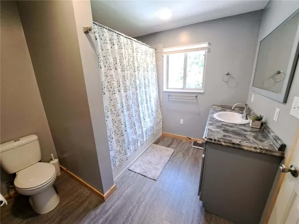 a bathroom with a granite countertop window a toilet and a sink