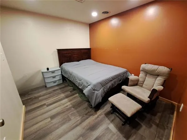 a bedroom with furniture and a wooden floor