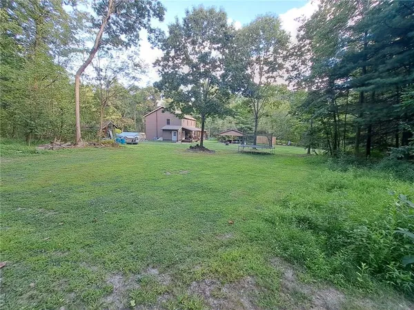 a backyard of a house with lots of green space and fountain