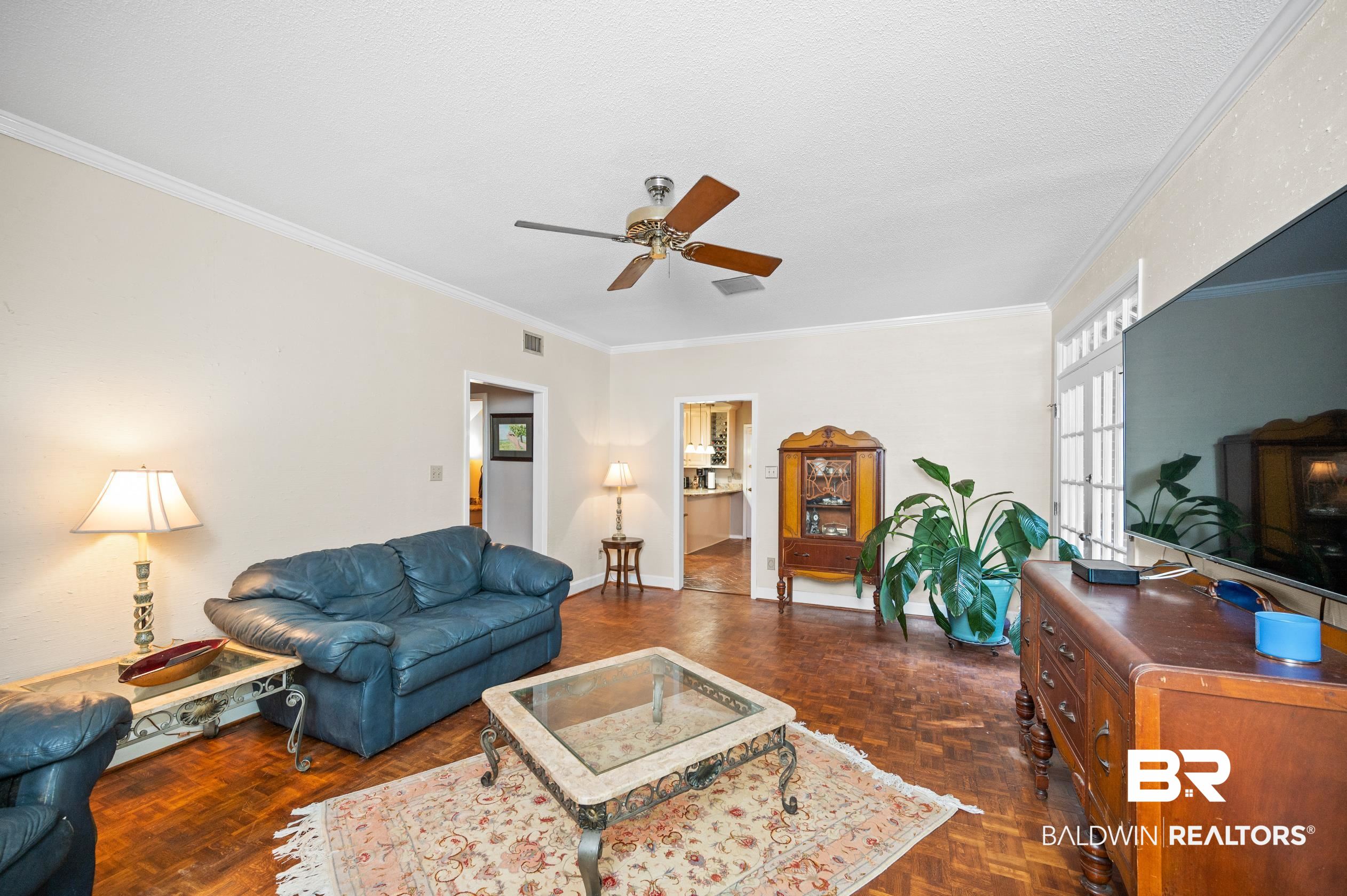 6705 Ridgeland Road South Mobile, AL 36695 - Photo 21 of 44 Living room with crown molding, dark parquet floors, and a textured ceiling