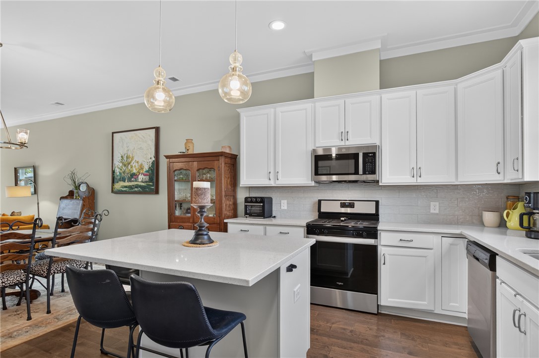 112 Tuttle Street Clemson, SC 29631 - Photo 17 of 46 An inviting kitchen with a central island and white cabinetry, ready for culinary endeavors.