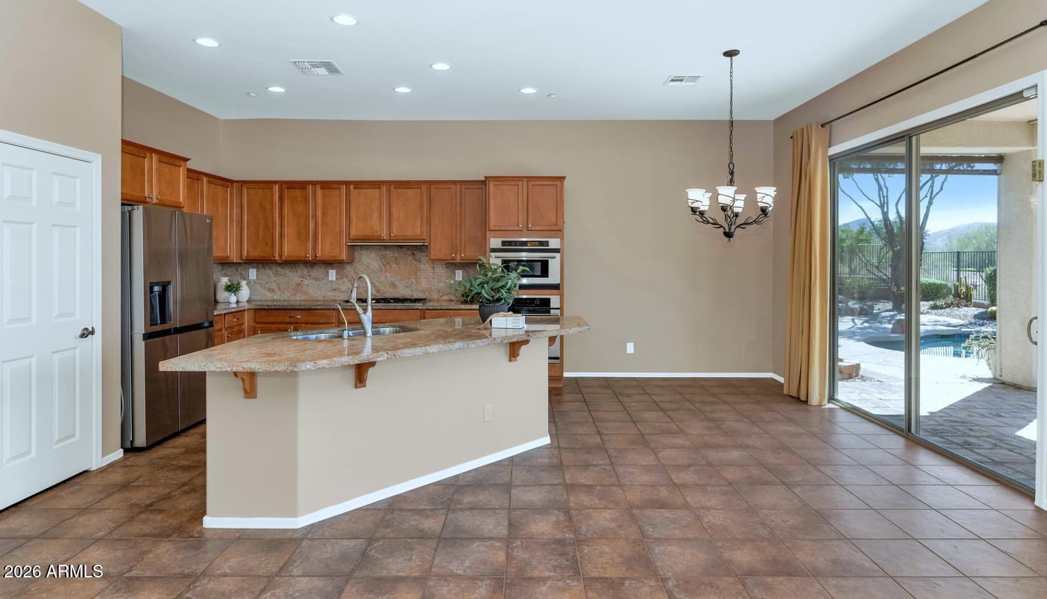 41123 North River Bend Road Phoenix, AZ 85086 - Photo 11 of 45 a kitchen with kitchen island a counter top space appliances and a chandelier