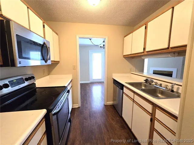 a kitchen with stainless steel appliances a sink stove and refrigerator