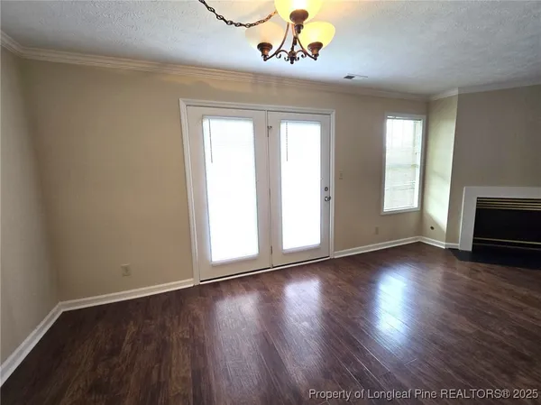 a view of a room with a fireplace and wooden floor