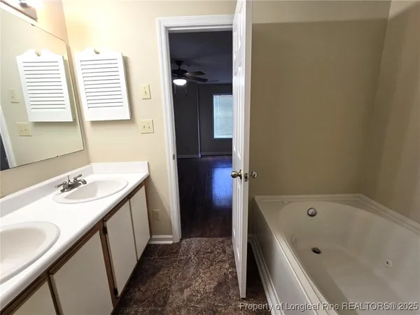 a bathroom with a tub sink and a mirror