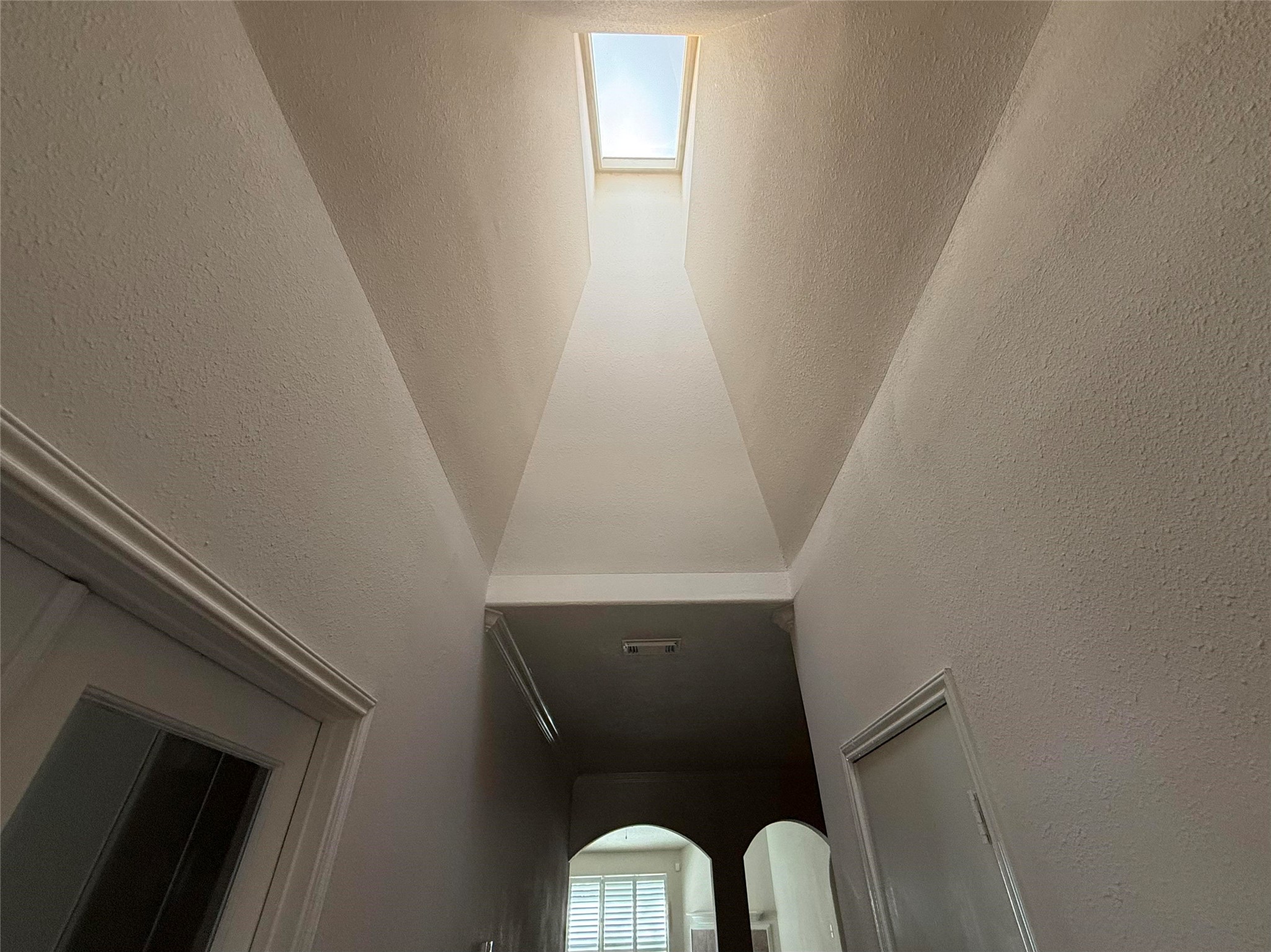 13102 Castlewind Lane Pearland, TX 77584 - Photo 13 of 31 Bright hallway featuring a beautiful skylight that fills the space with natural light.